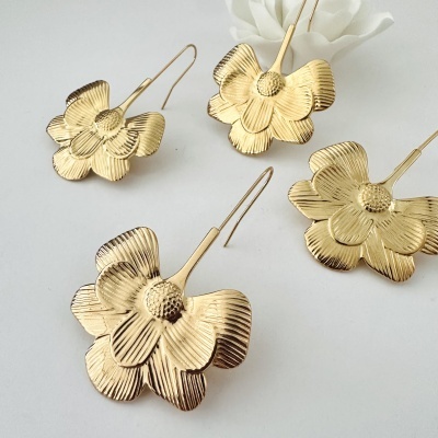 Brincos dourados em formato de flor com textura detalhada