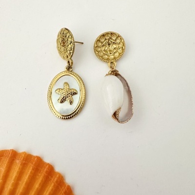 Par de brincos dourados com pendentes de estrela do mar e concha