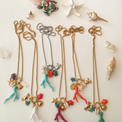 Colares com pendentes coloridos de coral, estrelas do mar e conchas naturais em fundo branco