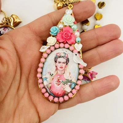 Colar pendente decorativo com imagem vintage de mulher com flores, conta-cor rosa e detalhes dourados.