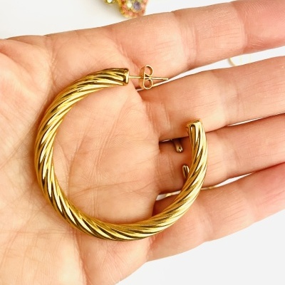 Brinco argola dourado com textura torcido na mão