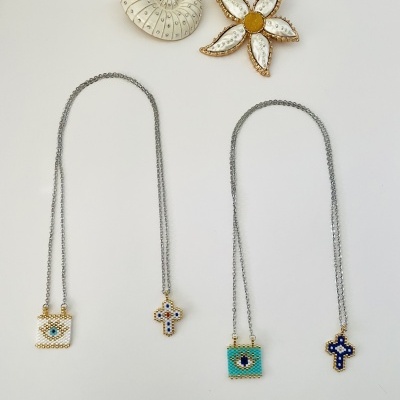 Dois colares com pendentes coloridos e dois broches decorativos em fundo branco