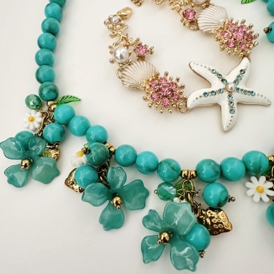 Colar com contas turquesas e flores verdes, pulseira dourada com conchas, pérolas e estrela do mar branca