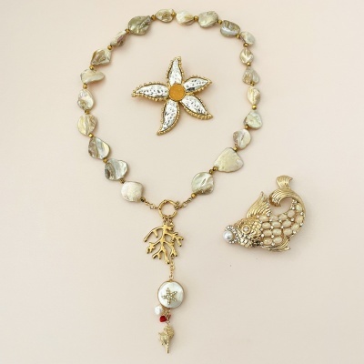 Colar com contas peroladas e broche em forma de peixe dourado com pérola