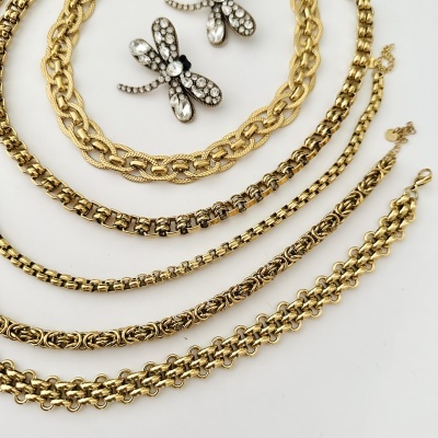 Colares e pulseiras dourados com pingentes de libélula em fundo branco