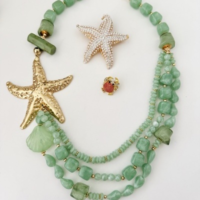 Conjunto bijuterias com colar verde e pingentes temáticos marinhos em fundo branco