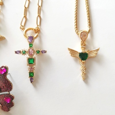 Dois colares dourados com pendentes em forma de cruz com pedras coloridas