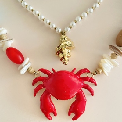 Colares com pingente em forma de caranguejo vermelho e concha dourada