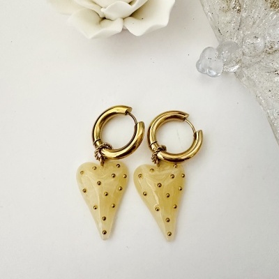 Brincos dourados com pendentes em forma de coração bege