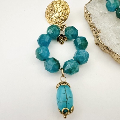 Brinco com pedras azul-esverdeadas facetadas, pingente azul turquesa e detalhes dourados