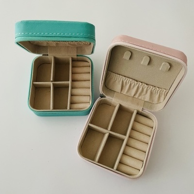 Caixas organizadoras de joias em verde água e rosa claro com interior estofado e compartimentos