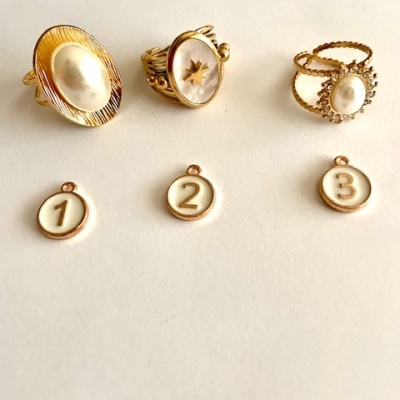 Três anéis dourados com pérolas e três medalhas numeradas