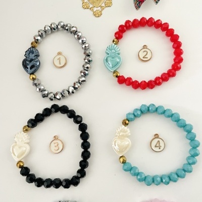 Pulseiras elásticas com contas facetadas coloridas e corações decorativos, numeradas de 1 a 4 sobre fundo branco.