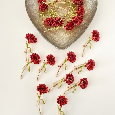 Prato de vidro em forma de coração com flores vermelhas artificiais