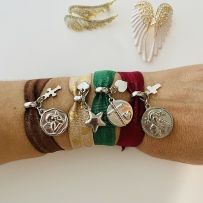 Pulseiras coloridas com pendentes metálicos prateados e brincos dourados em formato de asas