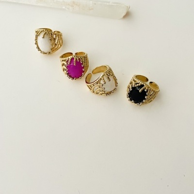 Quatro anéis dourados com pedras em várias cores e uma vara de cristal