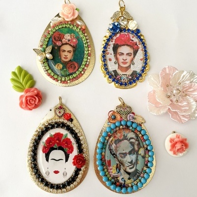 Pendentes coloridos com imagens de Frida Kahlo e outra figura, decorados com miçangas e flores, junto a acessórios florais pequenos.