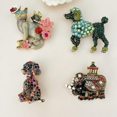 Quatro broches de animais decorativos em várias cores e materiais sobre fundo branco com flor de resina.