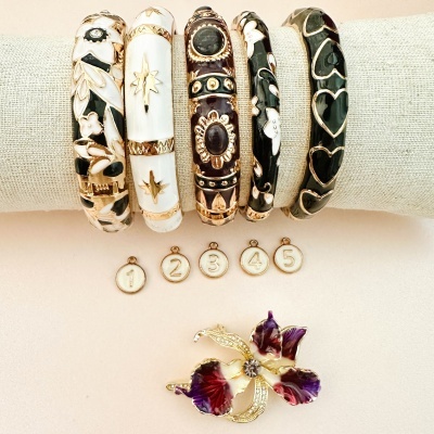 Conjunto de cinco pulseiras coloridas e broche florido com esmalte