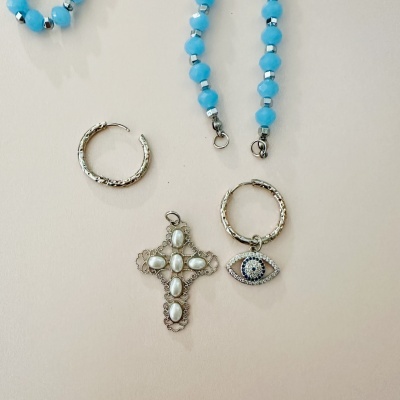Colares e brincos com contas azuis, argolas prateadas e pendentes em forma de cruz e olho turco