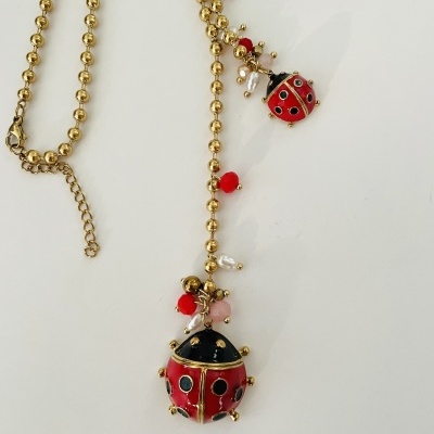 Colar dourado com pingentes de joaninhas vermelhas e pretas e contas coloridas
