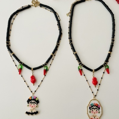 Dois colares com contas e pendentes de cabeça bordada e pimenta vermelha