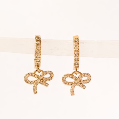 Brincos dourados com pendente de laço e pedras brilhantes