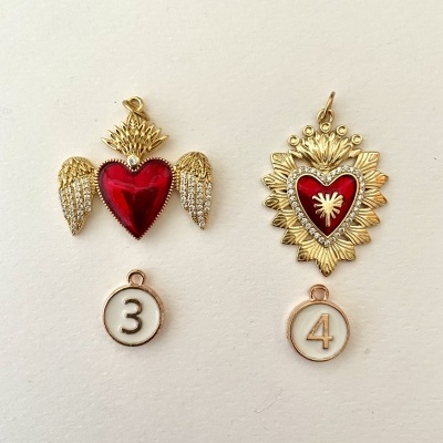 Pendentes dourados com corações vermelhos e números 3 e 4 em fundo branco