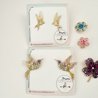 Conjunto de brincos de pássaros dourados com pedras e cartões de apresentação