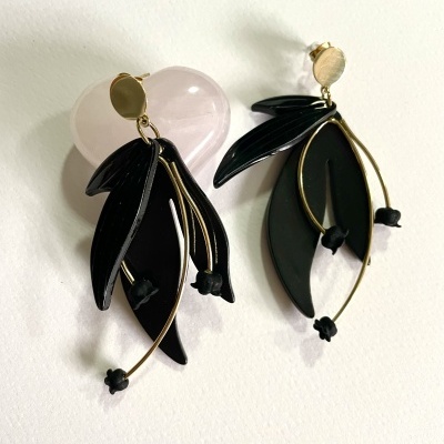 Brincos pendentes em preto e dourado sobre fundo branco