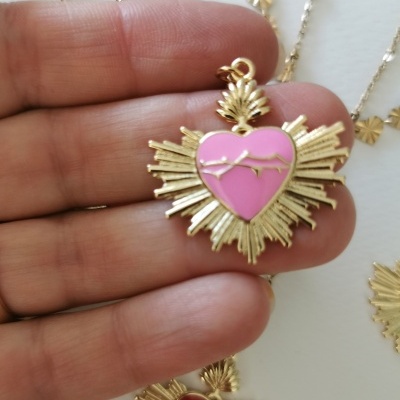 Colar pendente coração dourado com esmalte rosa e detalhes radiantes