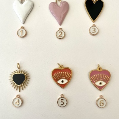 Seis pendentes em forma de coração, três lisos e três com design de olho, numerados de 1 a 6