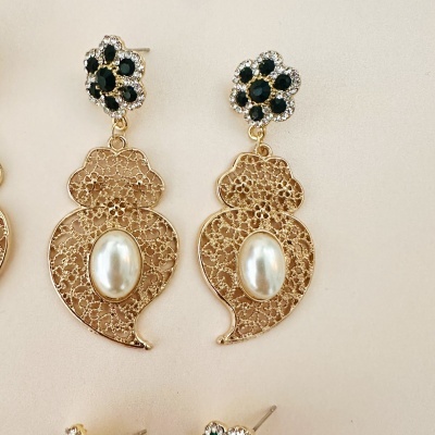 Brincos dourados com pérola e pedras pretas em forma de flor