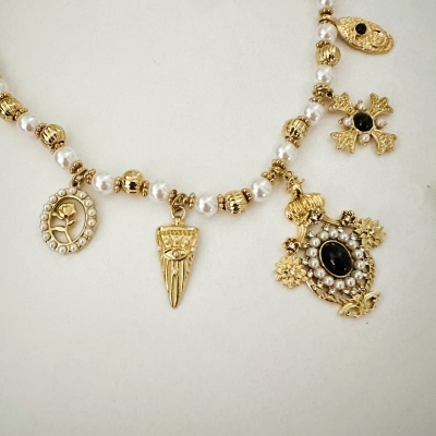 Colar dourado com pérolas e pendentes decorativos variados