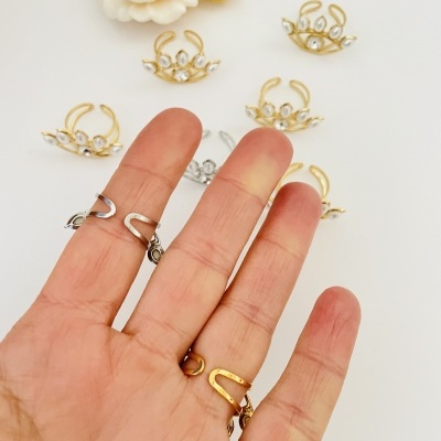 Mão segurando anéis metálicos dourados e prateados com detalhes curvos