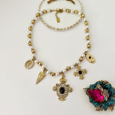 Colar de contas brancas e douradas com pendentes dourados e broche flor azul com pedras coloridas