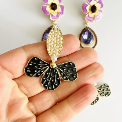 Brincos florais roxos com pendentes em preto e dourado