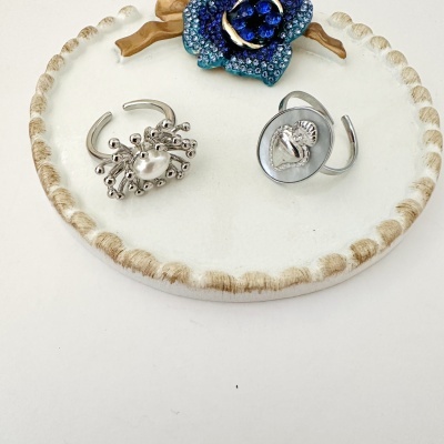 Anéis de prata com detalhes e borda dourada na base redonda