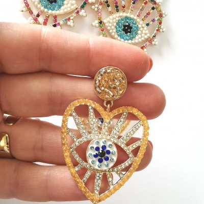 Brinco dourado em forma de coração com olho decorado por pedras coloridas