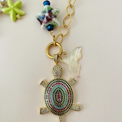 Colar com pendente de tartaruga colorida e corrente dourada com estrela do mar e concha