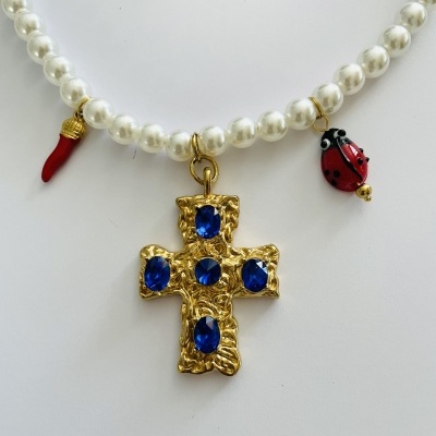 Colar de pérolas com pendente em cruz dourada com pedras azuis e pendentes de coral e joaninha