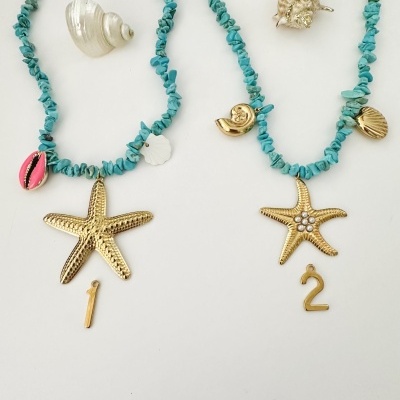 Dois colares de pedras turquesa com pendentes dourados de estrela-do-mar, números e conchas, sobre fundo branco e duas conchas naturais.