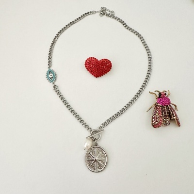 Colar prateado com pendente redondo e broches de coração vermelho e inseto rosa