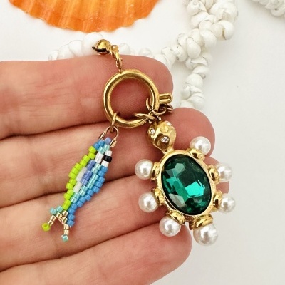 Colar com contas brancas, tartaruga dourada com pedra verde e pingente de contas coloridas em forma de peixe
