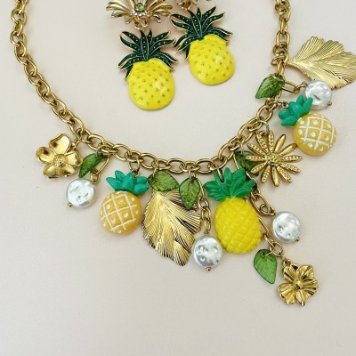 Conjunto de colar e brincos com abacaxis amarelos, folhas verdes e pérolas falsas