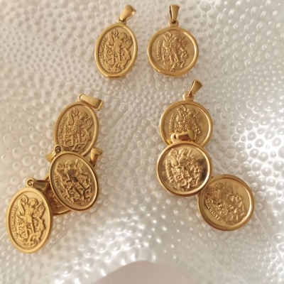 Dez medalhas douradas com figuras em relevo sobre superfície de vidro texturizado