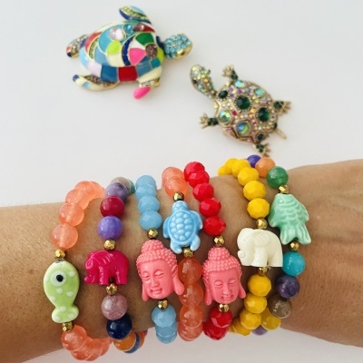 Pulseiras coloridas de contas redondas com figuras decorativas em um pulso