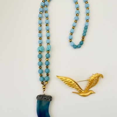 Colar azul com pendente e broche dourado em forma de pássaro