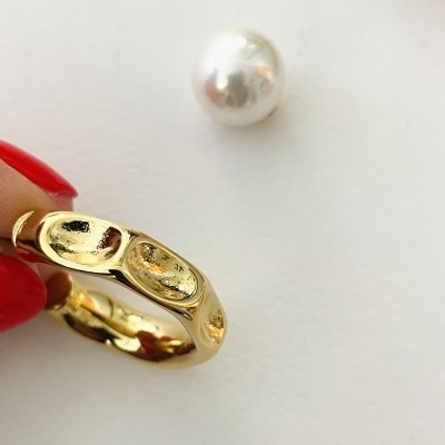 anel dourado brilhante com pérola branca num fundo branco