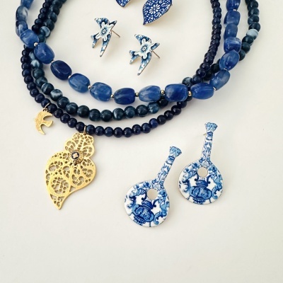 Conjunto de pulseiras e brincos com contas azuis, pendentes dourados e madrepérola com padrões azuis